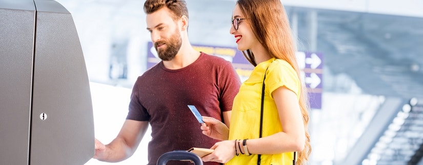 Un couple de voyageur utilisant une carte de crédit à l'aéroport