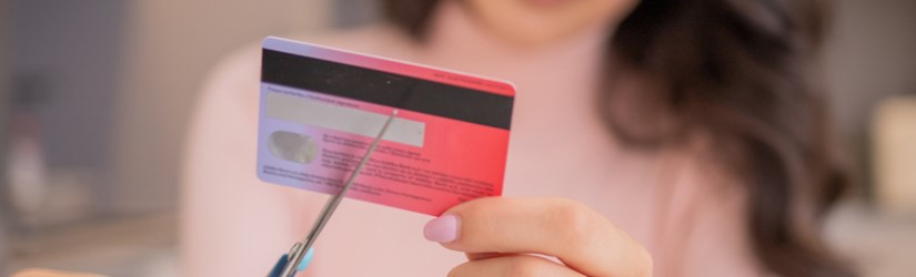 Une jeune femme en colère et mécontente détruit sa carte de crédit