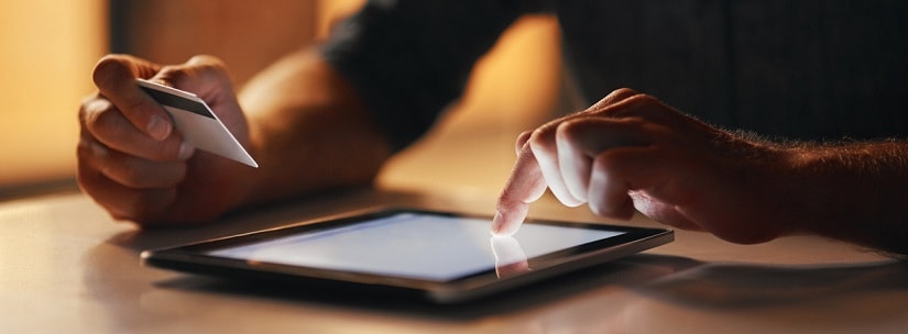 Une femme avec une tablette et une carte de crédit