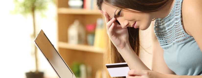 professionnelle contrariée essayant d'acheter en ligne avec une carte de crédit et un ordinateur
