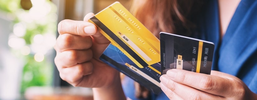 Une  jeune femme tenant et choisissant la carte de crédit à utiliser.
