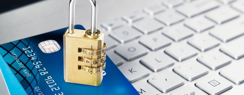 Photo d'un cadenas verrouillé avec des codes, sur 2 cartes bancaires sur un clavier
