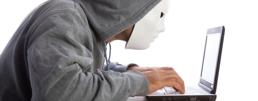 Un homme masqué en train d'escroquer sur Internet