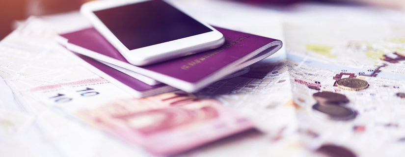 La monnaie euro,des passeports et un smartphone posés sur un plan