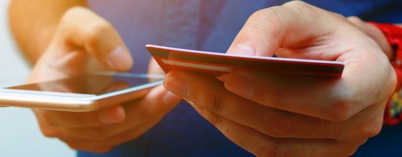 Une personne, carte de crédit et smartphone dans ses mains