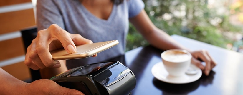 Jeune femme en train de payer par téléphone