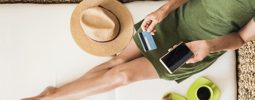 Une personne en vacances tenant sa carte de crédit 