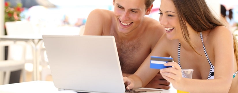 Un couple en vacances utilisant une carte de crédit