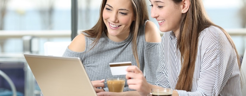 deux jeunes devant leur ordinateur avec carte de crédit