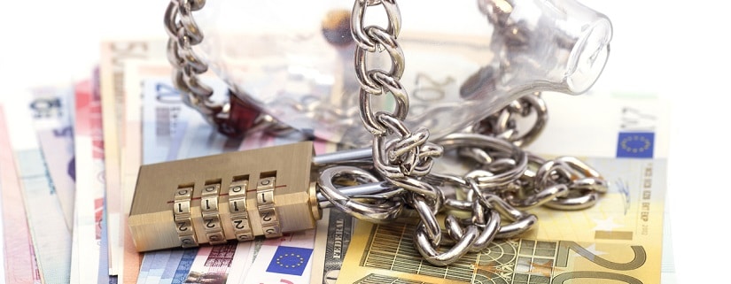 tirelire et billets euro enchaînés par un cadenas