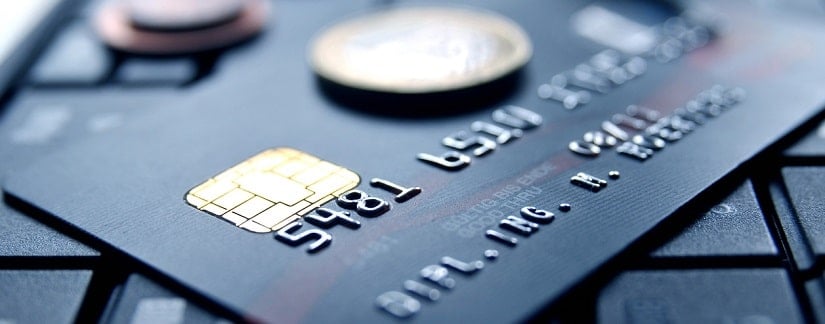 carte de crédit et pièces de monnaie posées sur un clavier 