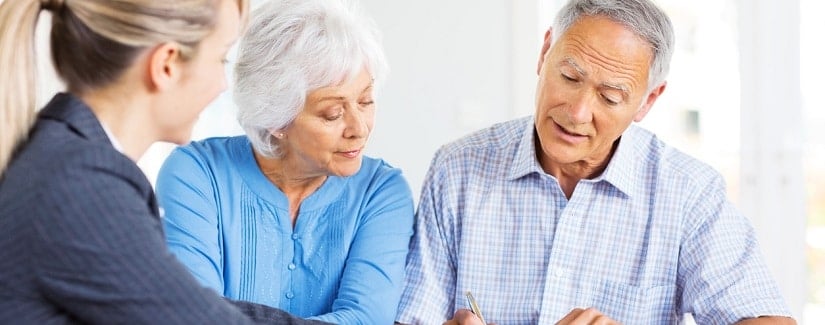 un couple âgé discutant des termes d'un contrat d'assurance