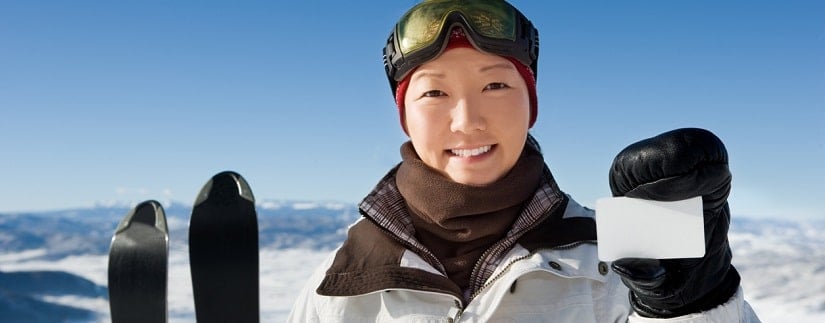 une skieuse avec sa carte bancaire