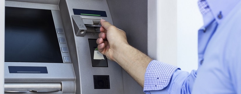 un homme utilisant un distributeur automatique bancaire