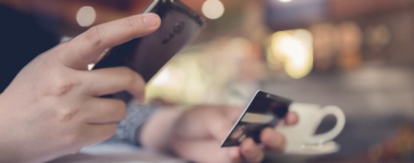 mains d'un homme smartphone et carte bancaire