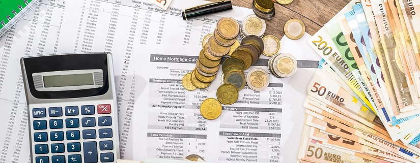 Des relevés bancaires avec des billets de banques et des pièces de monnaies ainsi qu'une calculatrice et un portefeuille contenant des cartes bancaires
