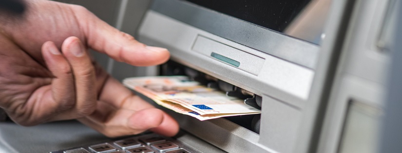 Une personne qui retire de l'argent auprès d'un distributeur