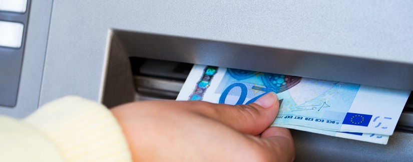 Une personne qui fait un retrait auprès d'un distributeur de billets 