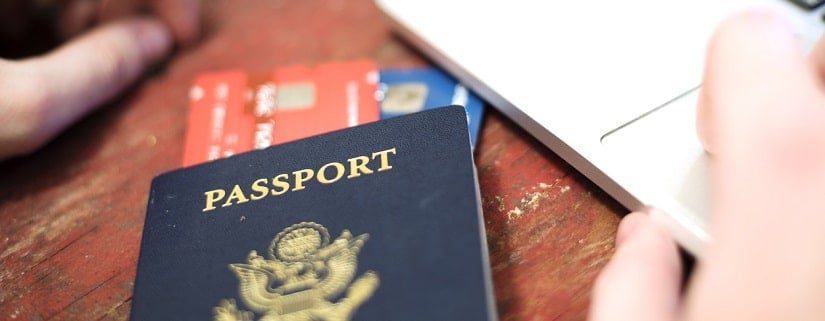 Des cartes bancaires dans un passeport et à côté d'un ordinateur 