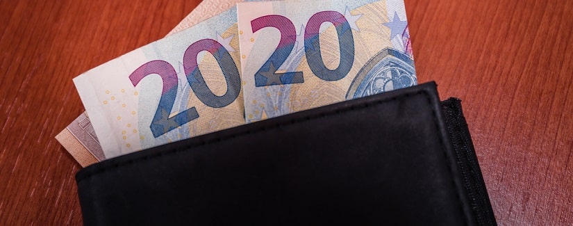 Portefeuille noir sur une table en bois avec des billets en euros