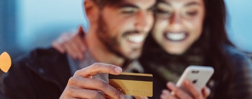 Jeune couple utilise une carte de crédit pour faire du m paiement en ligne