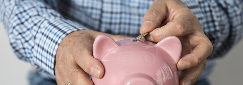Une personne âgée qui économise dans sa tirelire