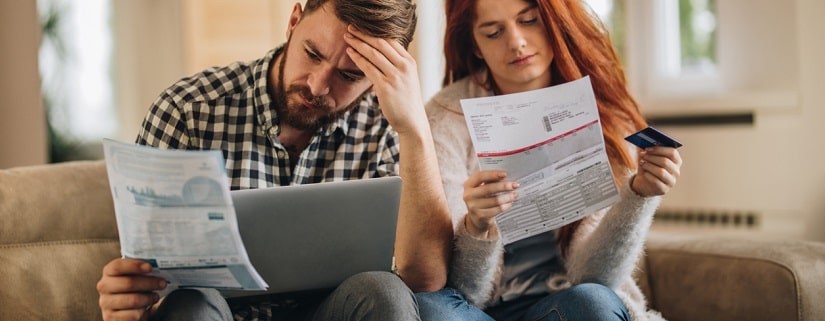 Un couple inquiet se sent frustré alors qu'il doit payer ses factures sur Internet.