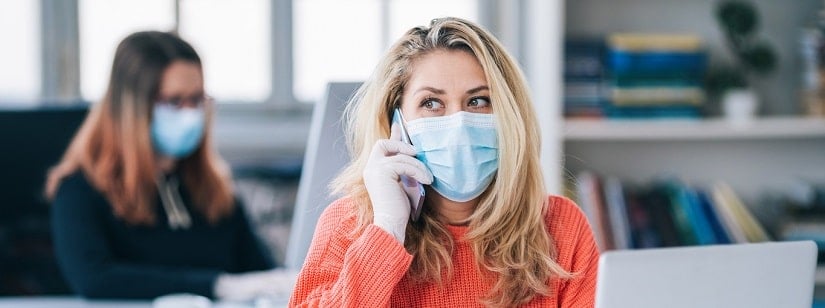 Collègues au bureau travaillant tout en portant un masque médical