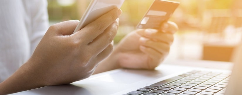 Femme d'affaires à l'aide de téléphone intelligent, carte de crédit et ordinateur portable pour les achats en ligne, paiement en ligne, services bancaires par Internet.