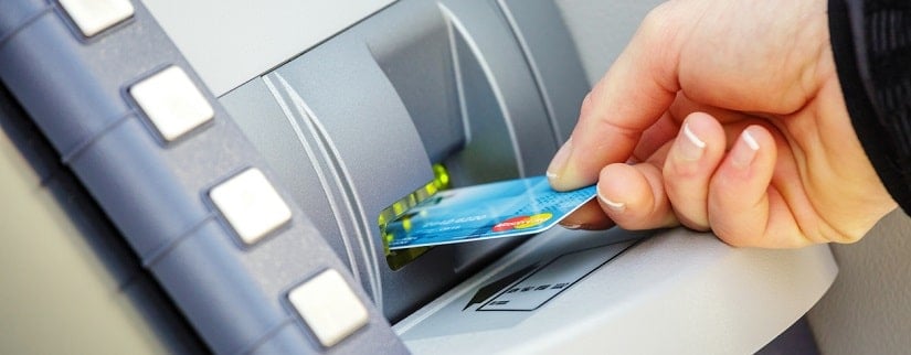 Insertion d’une carte bancaire dans un distributeur automatique.