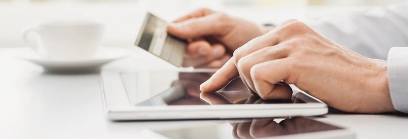 Jeune homme tien une carte de crédit avec tablette numérique à la maison