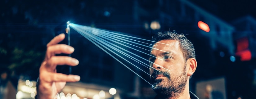 Homme utilisant un téléphone portable pour la reconnaissance faciale.