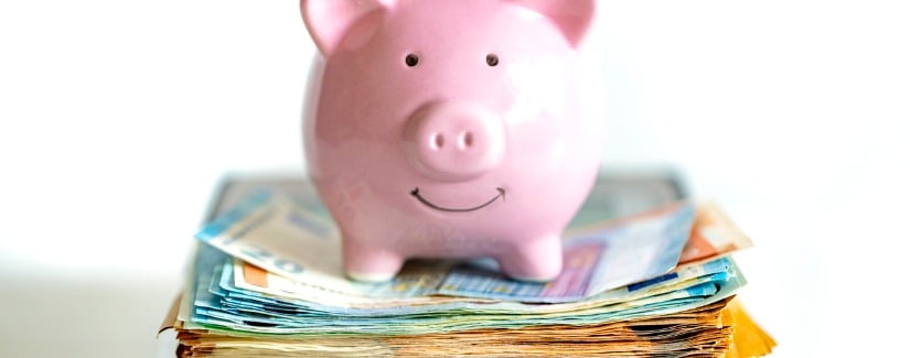 Tirelire se trouve sur un tas d'argent et calculatrice.