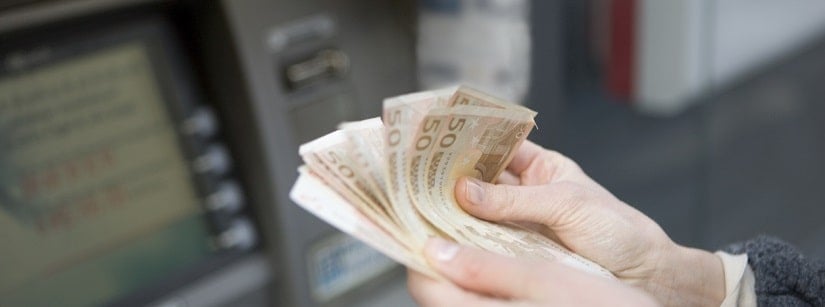 une femme tenant des billets euros