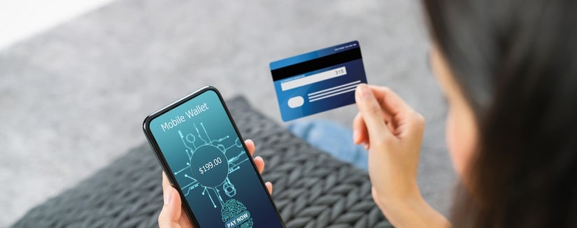 Femme détenant un téléphone intelligent et une carte de crédit avec numérisation des empreintes digitales biométriques pour obtenir l’autorisation d’accéder aux services bancaires mobiles de paiement dans le portefeuille de l’application.