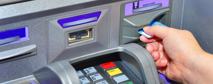 Femme utilisant sa carte de crédit sur un guichet automatique