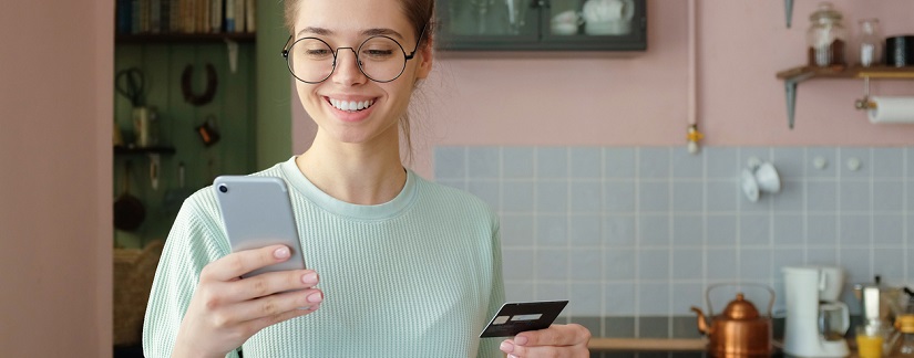 Photo en gros plan d’une fille caucasienne européenne utilisant un téléphone portable et une carte de crédit