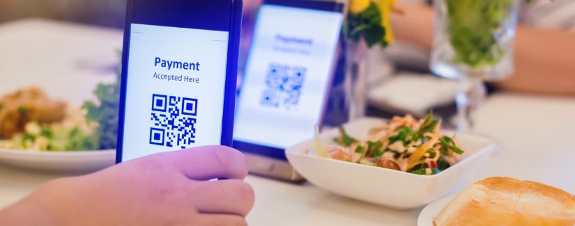 Focalisation sélective sur smartphone en main pour scanner le code QR sur l’étiquette avec la nourriture floue.