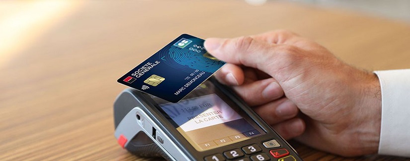 Main d’une personne tenant sa carte bancaire biométrique.