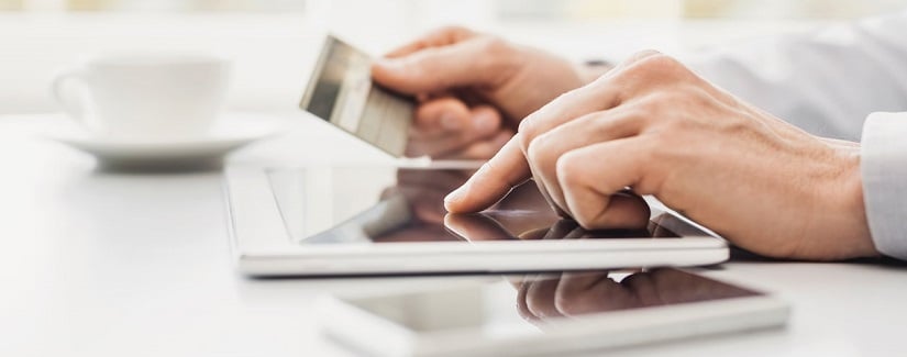 Jeune homme utilisant une carte de crédit avec tablette numérique à la maison