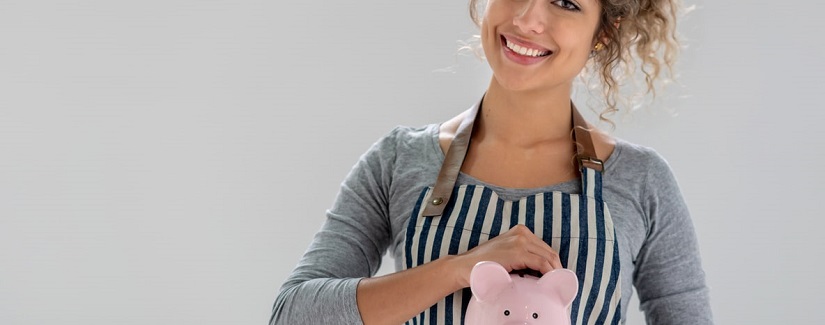 Portrait d'une jeune jolie fille économiser de l'argent sur son salaire dans une tirelire.
