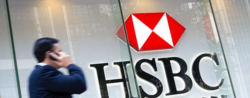 Un homme d’affaires dont le mouvement a brouillé les cartes en passant par une enseigne de la HSBC Bank à Hong Kong. 