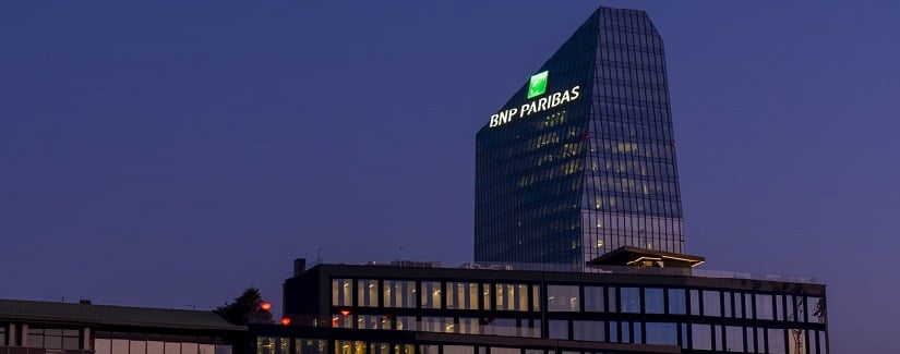 Siège de la banque française BNP Paribas à Milan avec le logo illuminé au coucher du soleil