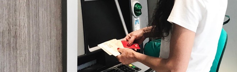 Femme retire de l’argent sur un distributeur de billet