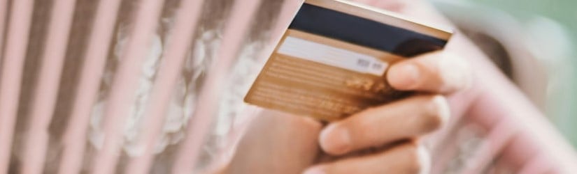 Une femme tenant une carte de crédit 