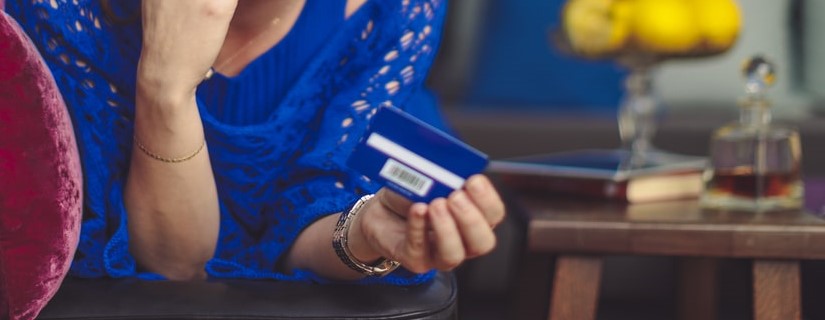 Une jeune jolie femme au téléphone tenant son crédit carte bleu.