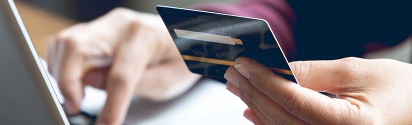 Les femmes asiatiques qui tiennent des cartes de crédit dans leurs mains et utilisent des ordinateurs portables pour acheter des produits en ligne.