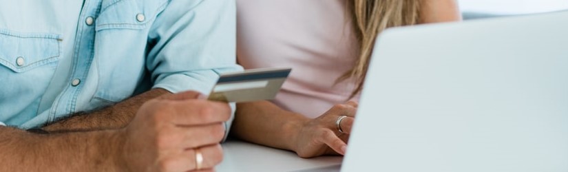 Couple faisant des achats en ligne avec une carte de crédit et un ordinateur portable.