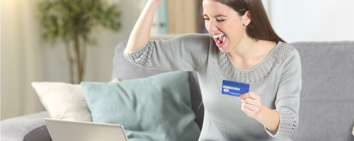 Un touriste enthousiaste paie en ligne avec sa carte de crédit pour planifier ses vacances.