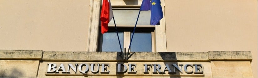 Écriture de la Banque de France sur un vieux bâtiment avec le drapeau français et européen.